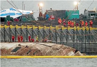  ?? PHOTOS: REUTERS ?? The sunken ferry Sewol is raised during salvage operations off Jindo, South Korea yesterday. More than 300 people, most of them high school students, died when the ship sank in April 2014.