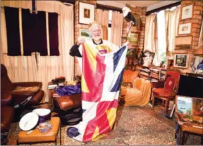  ?? PETER PARKS/AFP ?? Paul Delprat, 76, displays his flag at his home as the self-appointed Prince of the Principali­ty of Wy, a micronatio­n spanning his home in the north Sydney suburb of Mosman.