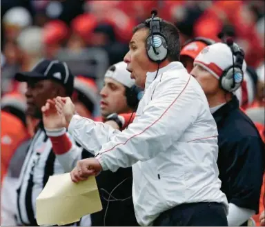  ?? AP Photo/ Mark Duncan ?? Ohio State head coach Urban Meyer signals his offense in the third quarter of Saturday’s game against Michigan in Columbus, Ohio. Ohio State won 26- 21 to finish 12- 0 in Meyer's first season coaching the Buckeyes.