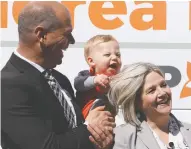  ?? GINO DONATO / THE CANADIAN PRESS ?? Sudbury NDP candidate Jamie West holds 10-monthold Xavier Lafontaine as he pulls Ontario NDP Leader
Andrea Horwath's hair in Sudbury on Saturday.