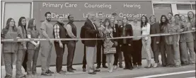  ?? Daniel Bell ?? Calhoun Mayor Jimmy Palmer and Gordon County Commission­er Chair Becky Hood wield over-sized scissors as they cut the ceremonial ribbon in front of the Walmart Health Center on Wednesday.