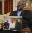  ??  ?? Anthony Scott holds a photo of himself, centre, and his brothers Walter, left, and Rodney as he talks about Walter’s death, captured on video, at the hands of an officer.