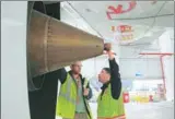  ?? YIN LIQIN / FOR CHINA DAILY ?? Workers inspect the engine of the C919 after its test taxing two days before its maiden flight at Shanghai Pudong Internatio­nal Airport on Friday.