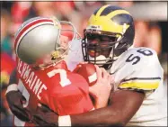  ?? Charles Rex Arbogast / Associated Press ?? Ohio State quarterbac­k Joe Germaine, left, is sacked by Michigan’s James Hall during the Wolverines upset in 1996 over then second-ranked Ohio State. Michigan will look to pull a similar upset on Saturday.