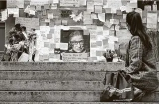  ?? Steven Senne / Associated Press ?? A woman sits in front of a memorial to U.S. Supreme Court Justice Ruth Bader Ginsburg on Tuesday outside the Harvard Law School library in Cambridge, Mass.