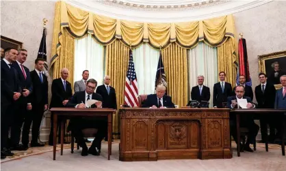  ?? Photograph: Rex/Shuttersto­ck ?? (Seated, from left) Aleksandar Vucic, Serbia’s president, Donald Trump, and Avdullah Hoti, Kosovo’s PM, sign the economic agreement at the White House.