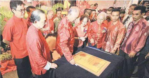  ??  ?? IMPRESSED: Najib (front row, second left), Taib (third right) and other guests looking at the certificat­e for the new record.