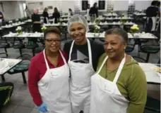  ??  ?? Volunteers Kenzie Rees, left, her son Nathan, 19, and her mother Ambah Rees are part of a small army helping get food to the tables.