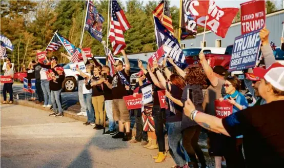  ?? JOSEPH PREZIOSO/AFP VIA GETTY IMAGES ?? Supporters of former president Donald Trump cheered as his motorcade passed outside the Manchester airport Wednesday.