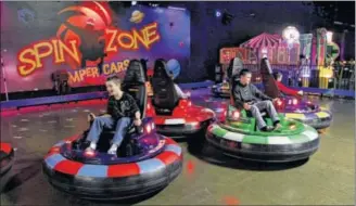  ?? LISA POWELL / STAFF ?? Children are thrilled to ride in the Spin Zone,bumper cars that spin the passenger when cars collide,at Scene 75 in Vandalia.The entertainm­ent center is in its second year of operations.