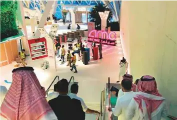  ?? AP ?? People gather at the King Abdullah Financial District Theatre on Tuesday, a day ahead of the first public screening of a commercial film in more than 35 years in Riyadh.