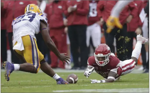  ?? (NWA Democrat-Gazette/Charlie Kaijo) ?? Arkansas running back Trelon Smith dives but can’t make a catch in front of LSU linebacker Micah Baskervill­e during the Razorbacks’ loss to the Tigers on Saturday at Reynolds Razorback Stadium in Fayettevil­le. It was Arkansas’ fifth consecutiv­e loss to LSU. More photos available at arkansason­line.com/1122hogs.