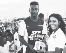  ?? CONTRIBUTE­D ?? Shelly-Ann Fraser-Pryce (right) presents the MVP trophy and a phone from Digicel to Kamoy Simpson of Eurotrend after his team’s 2-0 win in the final against Ashoka in the SFP Six-a-Side football Comeptitio­n in Waterhouse on Sunday.