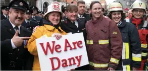  ??  ?? Firefighte­rs show their support for the controvers­ial commission­er, centre