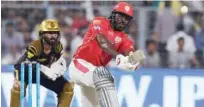  ?? Agence France-presse ?? Kings XI Punjab’s Chris Gayle plays a shot as Kolkata Knight Riders captain Dinesh Karthik looks on during their IPL match in Kolkata on Saturday.