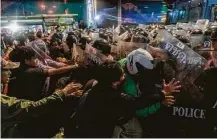  ?? Adam Dean / New York Times ?? Protesters clash with riot police in Bangkok. A new emergency decree allows police to declare any place off-limits to protesters.