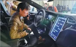  ?? MA NING / XINHUA ?? People experience Tesla’s new product in 2015. The company has been developing autonomous cars in