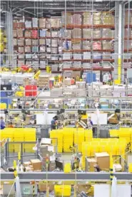  ?? STAFF FILE PHOTO BY ROBIN RUDD ?? The huge Amazon fulfillmen­t center processes orders in the Enterprise South facility. Amazon benefited from the shutdown and continued work-from home environmen­t and is adding employees at the center to prepare for holiday shipments.