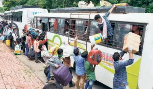  ??  ?? MIGRANTS who arrived from Kerala via a Shramik
Special train at Hatia Railway Station, Ranchi, on June 13. (Right) Migrants boarding a bus at the Delhi-noida border in New Delhi to travel to their native places in Bihar on June 13.