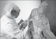  ?? Ap-Claudio Giovannini ?? A restorer works on one of Michelange­lo’s Pieta sculptures in Florence, Italy. Michelange­lo carved the Bandini Pieta between 1547-1555, when he was nearly 80.