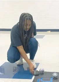  ?? ?? Imani Moore demonstrat­es how the robot competitio­n works during a lunch break at Hillcrest High School. The school’s robotics team recently competed in the Southworks Engineerin­g and Robotics Olympics at South Suburban College.