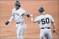  ?? Nick Wass / Associated Press ?? The New York Yankees’ Miguel Andujar, left, gets a fist bump from first base coach Reggie Willits (50) during a game in 2020.