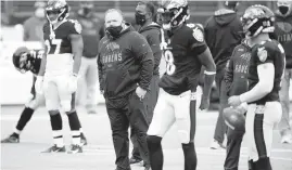  ?? NICK WASS/ AP ?? Ravens offensive coordinato­r Greg Roman, center, looks on during warmups before a game against the Titans.