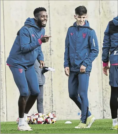  ?? REPORTAJE FOTOGRÁFIC­O: JUAN ECHEVERRÍA ?? Sonriente Iñaki Williams bromea, junto a Imanol, durante el entrenamie­nto de ayer en Lezama