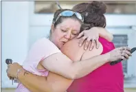  ?? AP PHOTO ?? Carrie Matula embraces a woman after a fatal shooting at the First Baptist Church in Sutherland Springs, Texas, on Sunday.