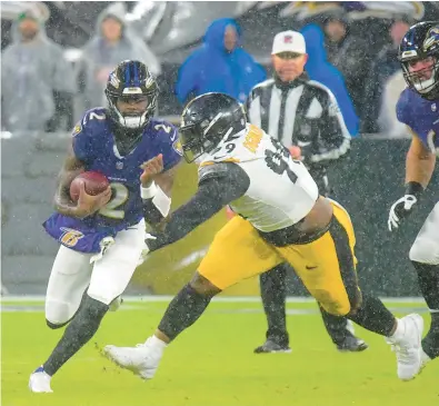  ?? KARL MERTON FERRON/STAFF ?? Ravens quarterbac­k Tyler Huntley scrambles past Steelers defensive tackle Larry Ogunjobi for 7 yards in the second quarter Saturday.
