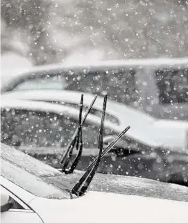  ?? H John Voorhees III / Hearst Connecticu­t Media ?? Cars parked at the War Memorial in Danbury with their wipers up for the wet snow that fell in the Danbury area on Jan. 25.