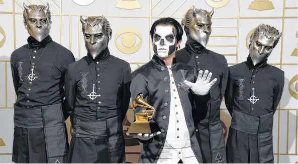  ?? AP PHOTO ?? In this 2016 file photo, Ghost poses in the press room with the award for best metal performanc­e for “Cirice” at the 58th annual Grammy Awards in Los Angeles. Ghost is up for best rock album and best rock song at the Grammy Awards on Sunday.