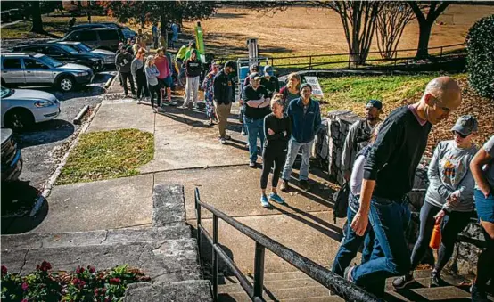  ?? RON HARRIS/ASSOCIATED PRESS ?? Voters in Atlanta waited in line to cast ballots on Sunday in the race between Raphael Warnock and Herschel Walker.