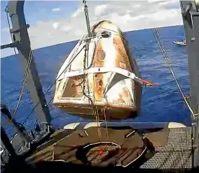  ?? AP ?? The SpaceX Dragon capsule is hoisted on to a ship in the Atlantic Ocean off Florida after returning from the Internatio­nal Space Station.