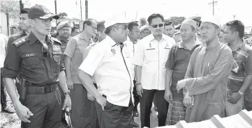  ??  ?? Sukarti (second left) speaking to the fire victims.