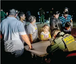  ?? Brandon Bell/Getty Images/TNS ?? ■ Border Patrol officers process a migrant family after they crossed the Rio Grande into the United States on Thursday in Roma, Texas.