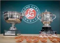  ??  ?? Men’s single (left) and women’s single cups are displayed during the draw of the French Open tennis tournament at the Roland Garros stadium in Paris on Thursday. The French Open tennis tournament starts Sunday, May 26.