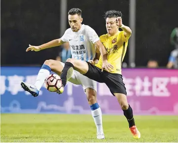  ?? — AFP photo ?? This photo taken on July 29, 2017 shows Israel football player Eran Zahavi (L) of Guangzhou R&F fighting for the ball against Zhouzheng of Guangzhou Evergrande in their 19th round match during the 2017 Chinese Football Associatio­n Super League in...