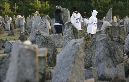  ??  ?? VISITORS WALK among stones at the Treblinka Nazi death camp memorial, eastern Poland.