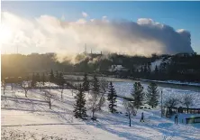  ?? DARRYL DYCK, THE CANADIAN PRESS ?? A man walks in frigid weather at Rundle Park as emissions rise from the Imperial Oil Strathcona Refinery in Edmonton this winter. Imperial Oil Ltd. says it earned $1.17 billion this quarter, boosted by higher oil prices.