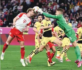  ?? (Reuters) ?? Bayern Munich’s Harry Kane (left) goes for a header as Borussia Dortmund’s Alexander Meyer makes a block during the Bundesliga match in Munich.