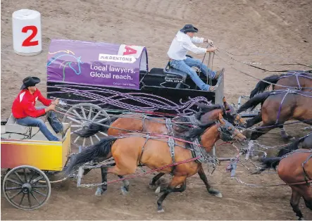  ?? DREW MIKE ?? Vern Nolin, left, fights off Kurt Bensmiller in one of Friday’s chuckwagon heats making up the GMC Rangeland Derby at the Calgary Stampede.