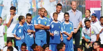  ??  ?? PRINCE WILLIAM poses with participan­ts of The Equalizer program yesterday in Jaffa after their exhibition soccer game.