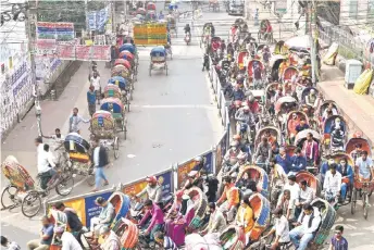  ?? ?? Bicycle rickshaw drivers transporti­ng passengers in Dhaka.