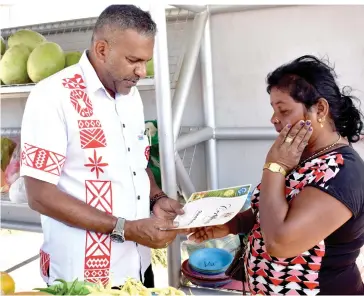  ?? Photo: Arieta Vakasukawa­qa ?? Fifty-four-year-old, Chandra Kumari breaks down in tears while receiving her Certificat­e for leasing the roadside semi permanent stall from the Minister for Industry, Trade, Tourism, Lands and Mineral Resources, Faiyaz Koya in Lomawai, Nadroga on July...