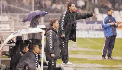  ??  ?? Pepe Moré y Emilio Isierte, bajo la lluvia, ordenan a sus jugadores desde el banquillo de Castalia.
