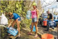  ?? VICTOR J. BLUE/THE NEW YORK TIMES ?? Luz Rosado, center, directs the filling of water vessels at a natural spring at her home in Toa Alta, Puerto Rico, earlier this week.
