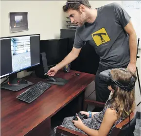  ?? UNIVERSITY OF GUELPH ?? Andrew Vierich, a University of Guelph software developer, looks on as Ruby Corbett learns how to safely cross streets using a virtual reality program.