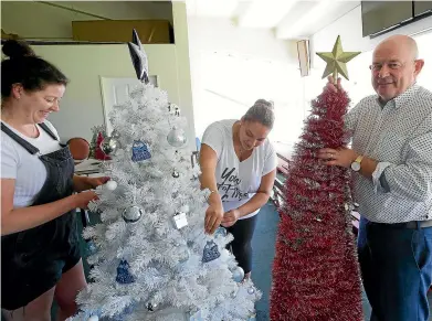  ?? ROBYN EDIE/STUFF ?? Southland Racing Club volunteers, Hannah Dawson, left, and Brittany Francis, prepare Christmas trees with president Sean Bellew ready to help, at Ascot Park Raceway yesterday. The club’s biggest race day of the year is today.