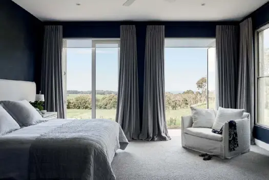  ??  ?? MAIN BEDROOM Dark and moody tones invite deep relaxation in Diana and Tom’s domain (above). Juxtaposed against a wall clad in Porter’s Paints ‘Navy’ Grasscloth wallpaper, a bespoke bedhead by Peoni Home is teamed with a bed dressed in Abbotson linen from Sheridan. “The navy wallpaper brings such a texture and depth to the room,” notes Diana, who can also take in the view curled up in the cosy ‘Vittoria’ slip cover sofa chair from Globe West.